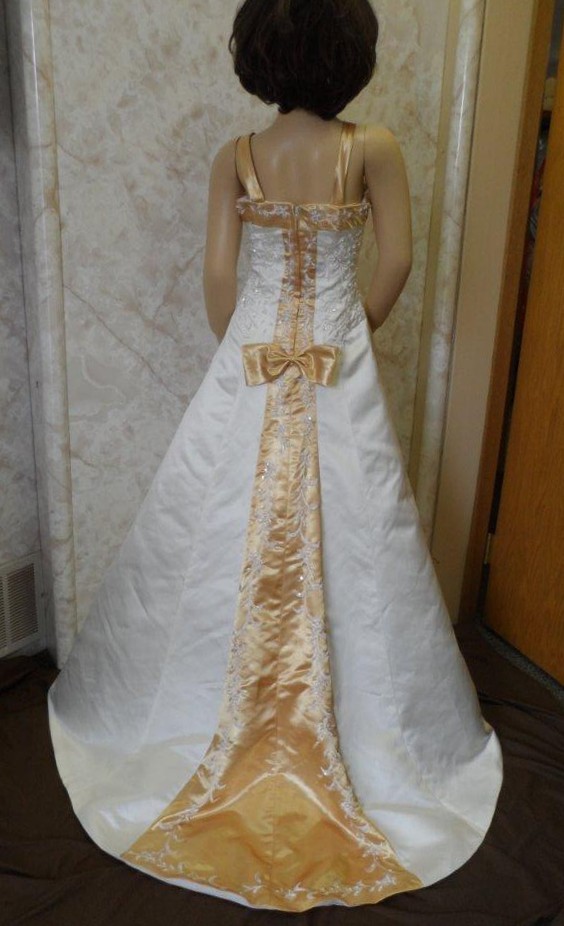 Ivory miniature wedding, flower girl dress with colorful gold, accented with and white embroidery running down the train.