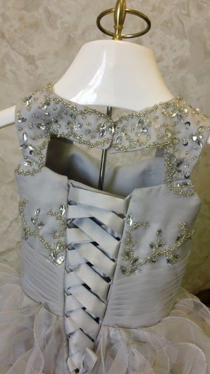 silver infant wedding dress has a keyhole back, and silver & crystal beads sprinkled on the bodice. 