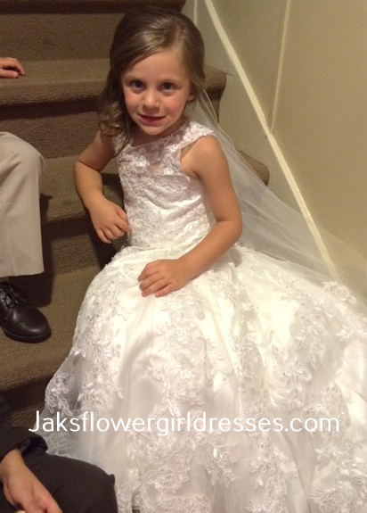 Lace flower girl dress with train was designed to match the brides dress.