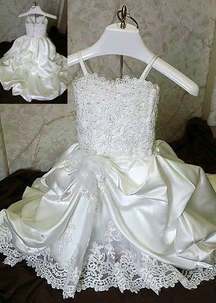 Lace infant flower girl dress. Spaghetti strap, lace embellished bodice and underskirt is finished with a train.