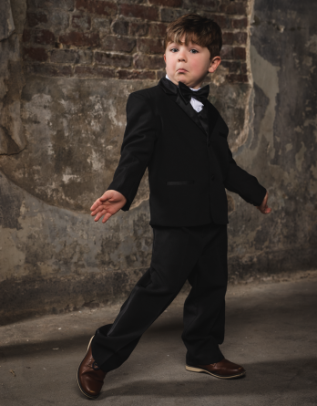 Boys 5-piece black tuxedo for infants to teenagers. Black, Ivory, or White Tuxedo includes a jacket, pants, vest, shirt, and a bow tie.
