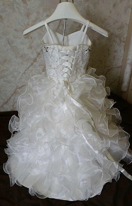 Charming baby wedding dress with a sweetheart beaded bodice and elaborate organza ruffle skirt with train.