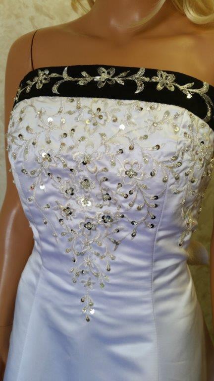 White dress for wedding flower girls. Black trimmed neckline, lace up back and chapel train with beaded embroidery.