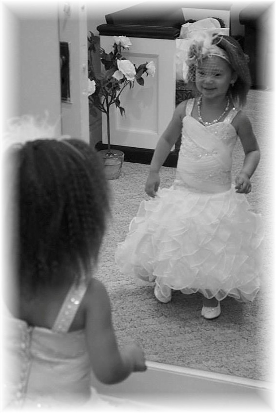 This charming young flower girl looks gorgeous in her dress.