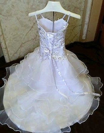 White Mermaid-style toddler flower girl dress with silver applique and beading.  Sweetheart spaghetti strap bodice, and corset lace-up back.