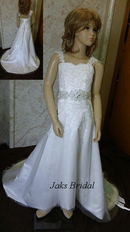 Lace flower girl dress with bridal sash and a floor length skirt with a train.