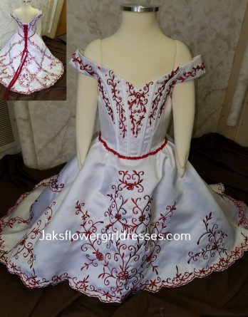 Red and white infant flower girl dress has off-shoulder sleeves & embroidery.