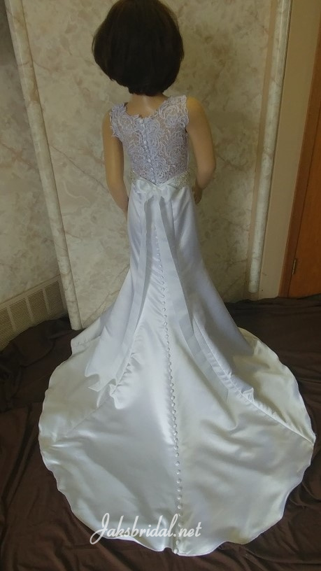 V-neck fit and flare flower girl dress with lace illusion back, silver beaded sash, and covered buttons running down the train.