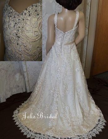 A girls satin light champagne wedding dress with sweetheart neckline, and ball gown skirt.  This lace embellished flower girl dress has a beaded neckline and a beautiful train.