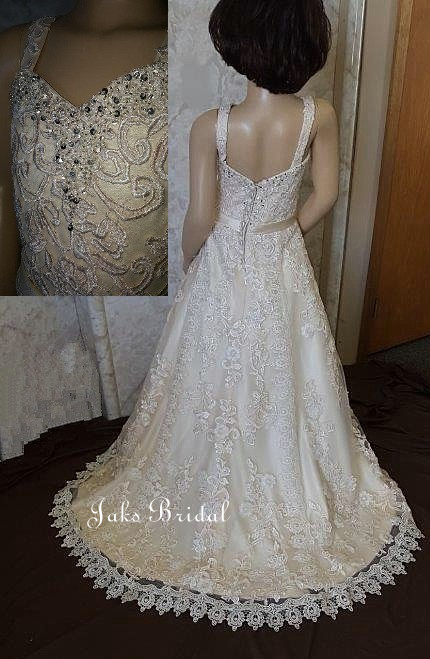 A girls satin light champagne wedding dress with sweetheart neckline, and ball gown skirt.  This lace embellished flower girl dress has a beaded neckline and a beautiful train.