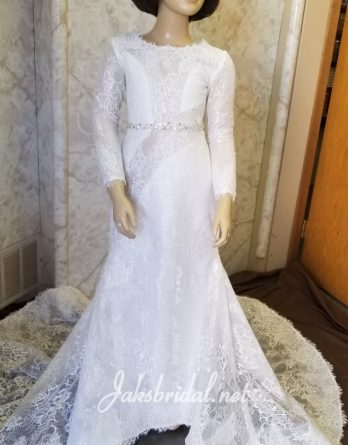 Light ivory lace dress with an illusion bateau neckline, beaded waist, and tastefully inserted illusion panels make this a high fashion flower girl dress. Completed with lace illusion long sleeves and train.