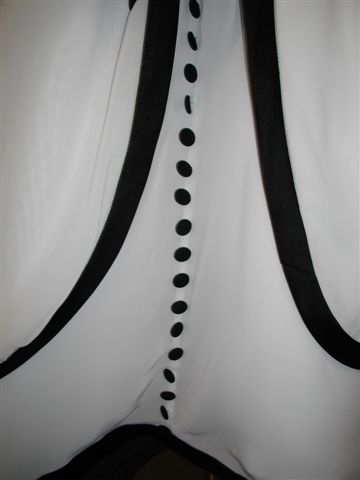 A black organza bodice and ivory skirt, with black sash, trim, and buttons flowing down the back of the dress. On sale for $50.