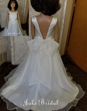 Organza plunging back dress with a soft bow at the waist. This floor-length dress has a round neckline, and a small train, accented with covered buttons.