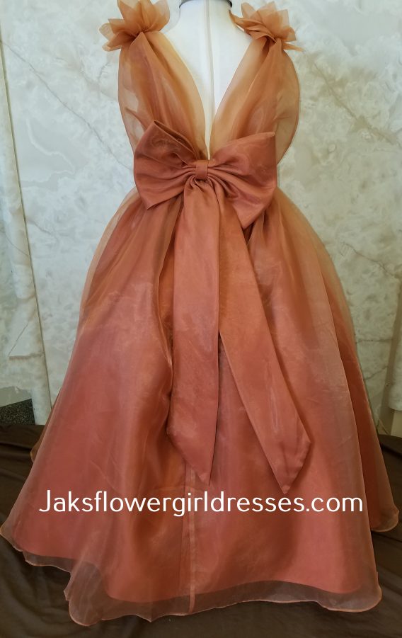 Girls long A-line orange organza flower girl dress with a v-back and bow on the waist.