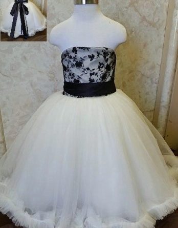 Floor-length black and ivory tulle flower girl dress. Black lace bodice and sash.