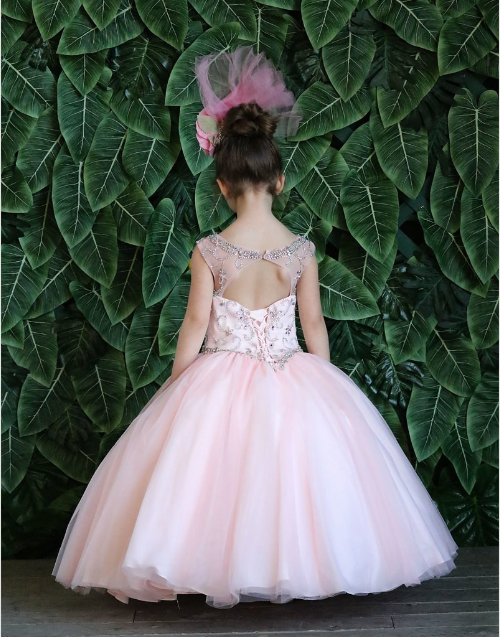 Blush sleeveless girl's ball gown has an embellished bodice, illusion neckline, and voluminous skirt