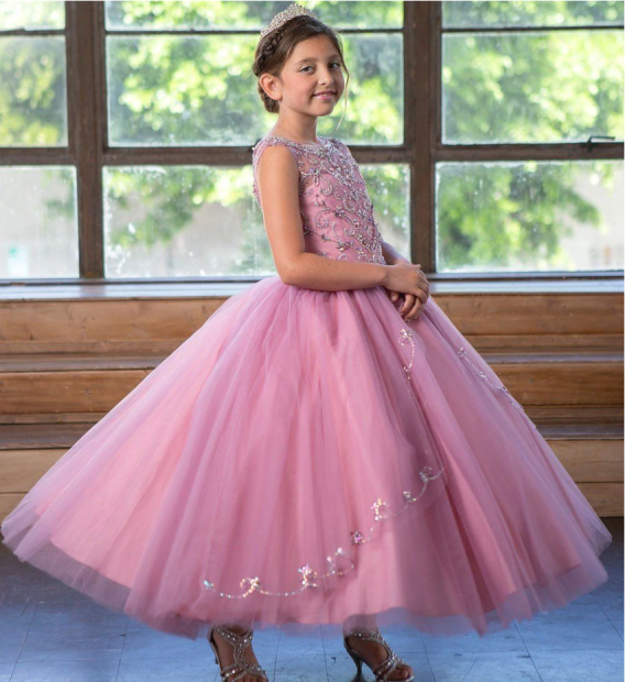 Mauve sleeveless girl's ball gown has an embellished bodice, illusion neckline, and voluminous skirt