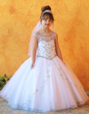 White sleeveless girl's ball gown has an embellished bodice, illusion neckline, and voluminous skirt.  