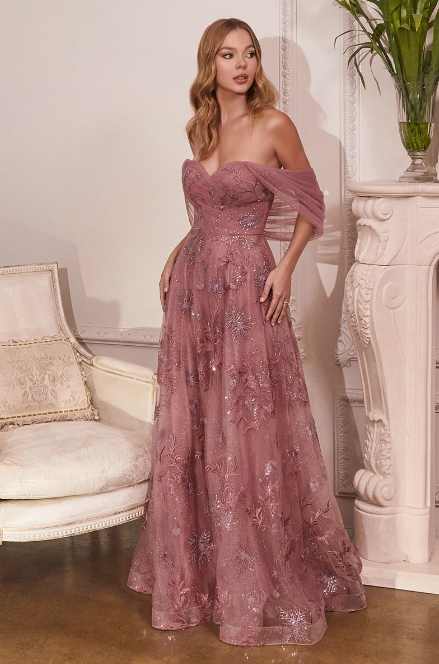 Dusty rose floral applique dress with a plunging neckline and flowing tulle skirt. An A-line off-shoulder sweetheart neckline with floral and glitter accents.