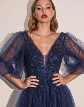 GLITTER TULLE A-LINE NAVY DRESS. Sheer sleeve glitter tulle dress with a plunging neckline and a deep back.  Covered with appliqued with embellished lace.