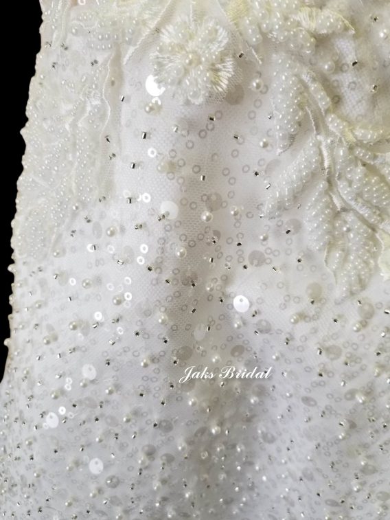 Baby girl dresses for wedding covered with lace, sequins and pearls and a sheer off the shoulder design.